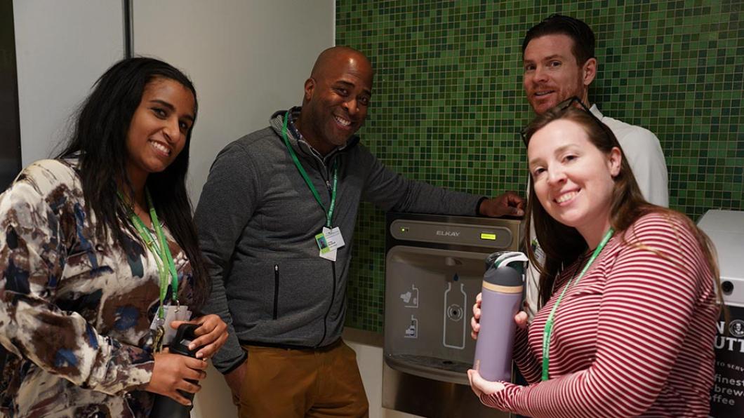 Four people are trying the new water machine