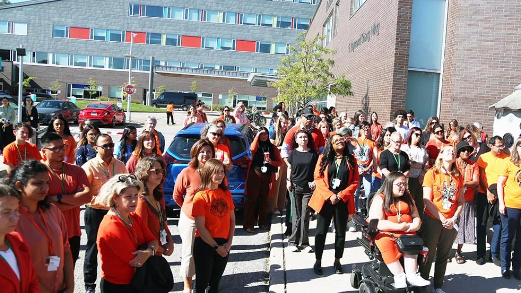 Group photo of people in orange shirt