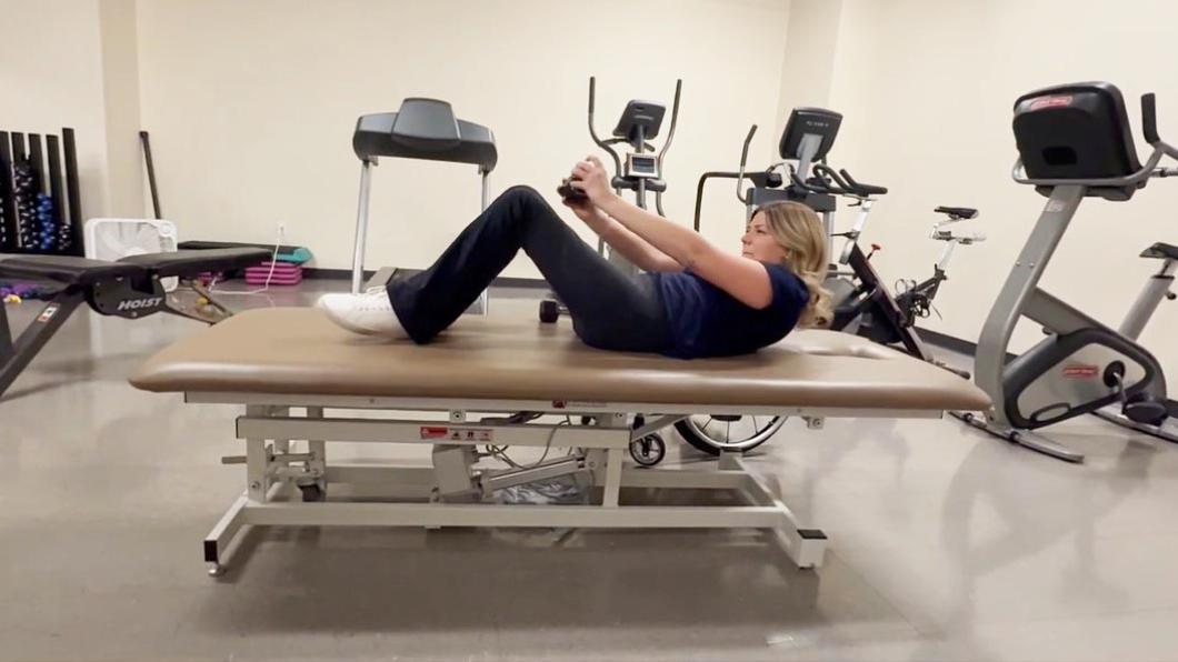 A person doing workout on a gym bed