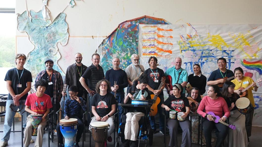 HB Rocks band members pose with volunteers, staff, and members of The Jam music hobbyist group.