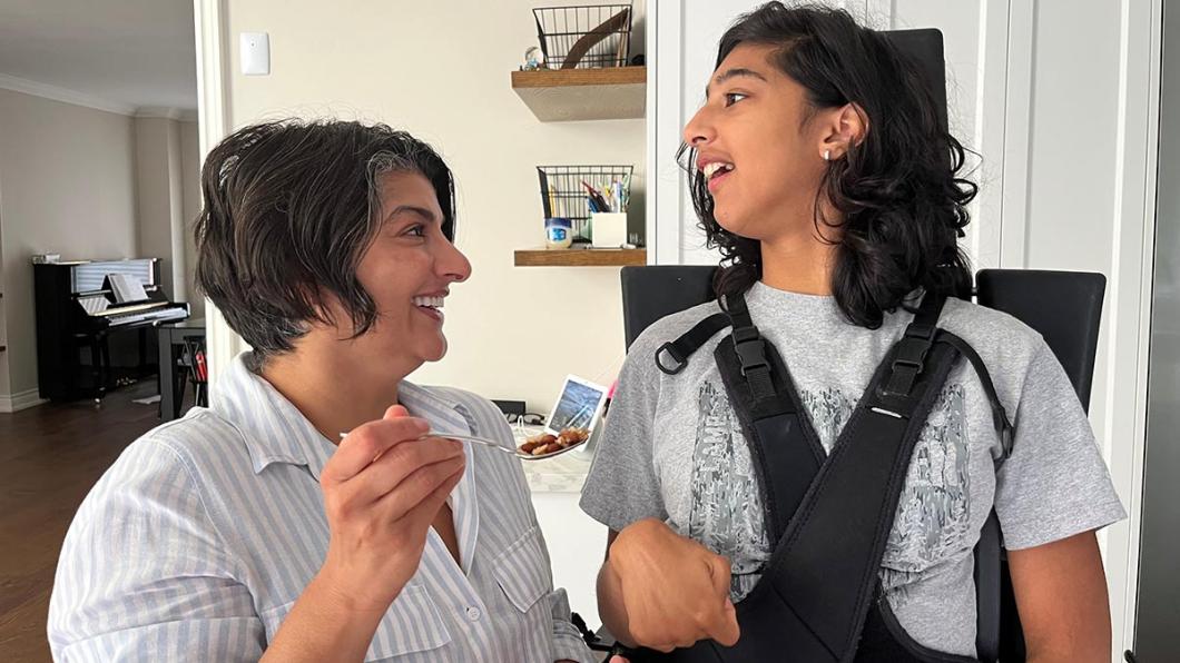 Woman feeds teen girl who uses wheelchair