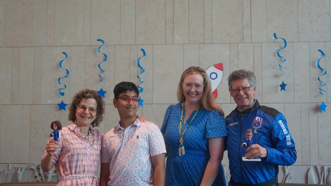 A group of adults and a kid smile