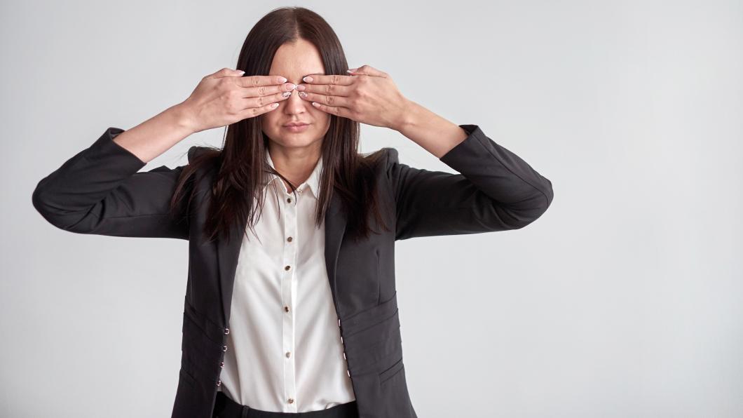 Woman puts hands over eyes