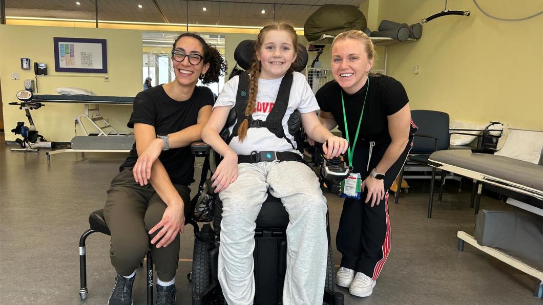 Two adults with a child on a wheelchair