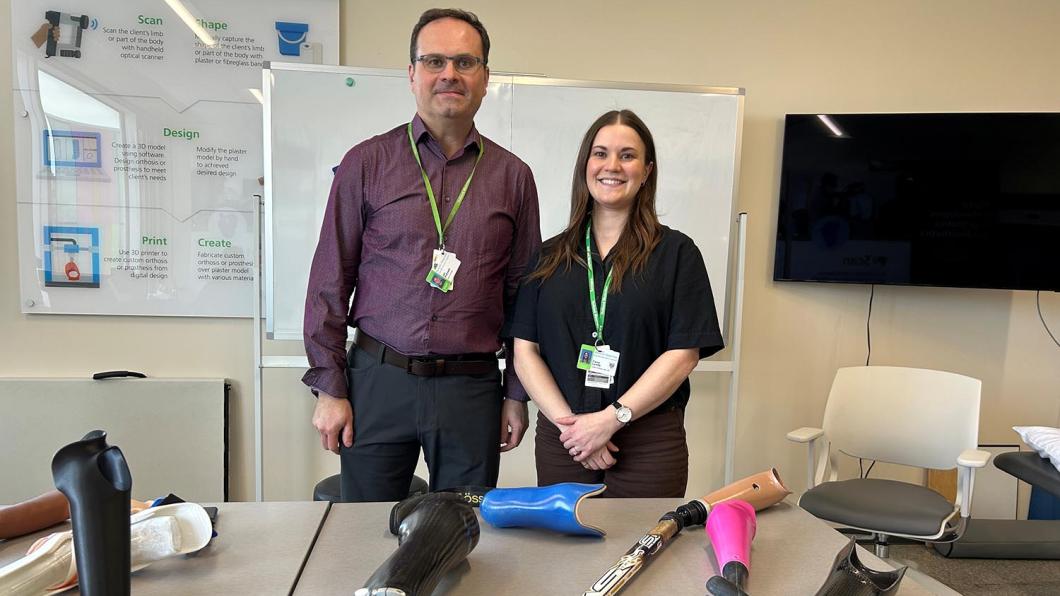 A man and a woman standing behind some tools for disabilities