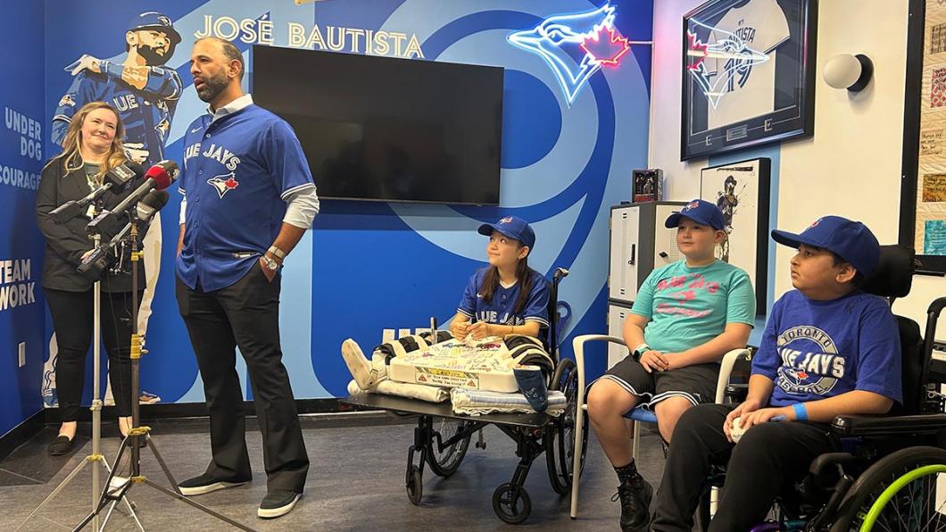 A group of people in an indoor setting, with some Blue Jays logos