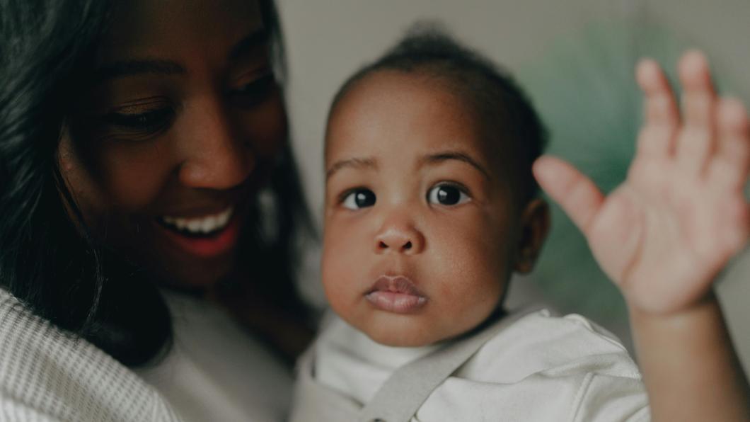 Baby waves in woman's arms