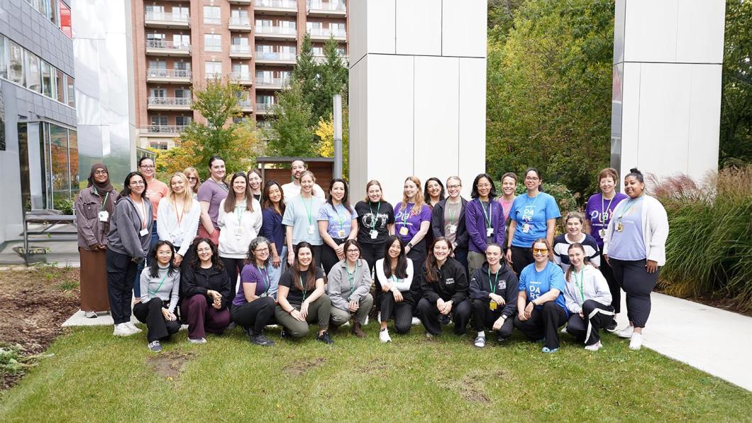 A big group of people having a group photo in an outdoor setting