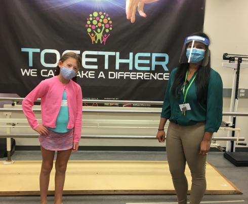 Amira Zarem (left) and Dr. Teenu Sanjeevan (right), a research fellow at the Bloorview Research Institute, pose for a photo after completing a balancing exercise as part of Amira's assessment for Teenu's onsite research study.