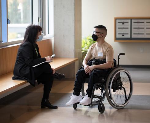 A Holland Bloorview staff member sitting with a client.