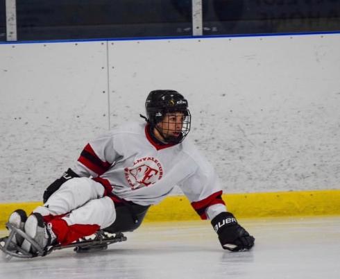 A young boy plays sledge hockey.