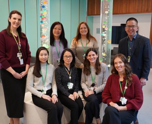 group of adults, some sitting and others standing, in a room with bubble towers in the background