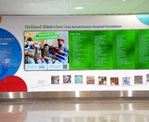 A colourful digital display featuring names of various donors