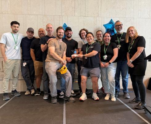 group of clinicians standing in atrium and posing for a photo 